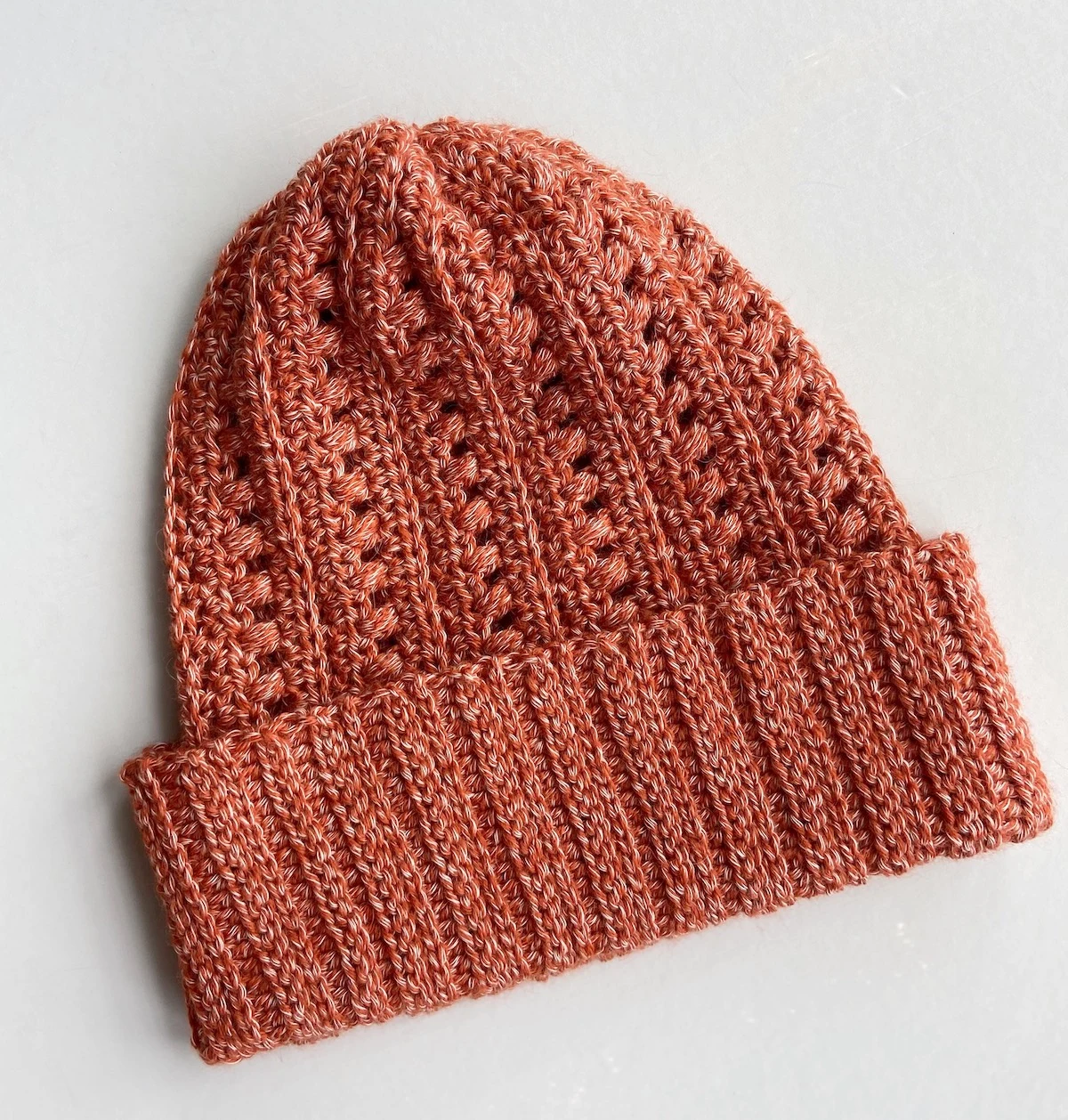 flatlay image of slouchy crochet hat pattern in a rusty orange colour and knit look wide brim