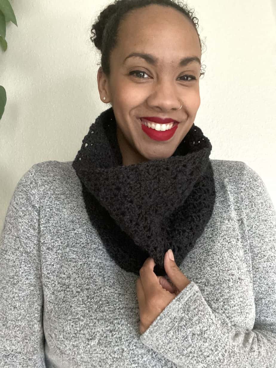 Smiling woman wearing black scarf.