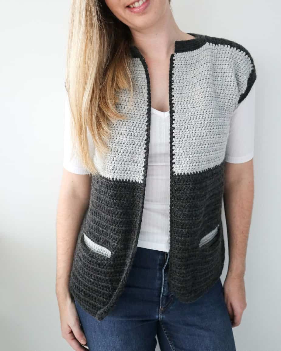 Woman wering trendy crochet vest in dark and light grey.