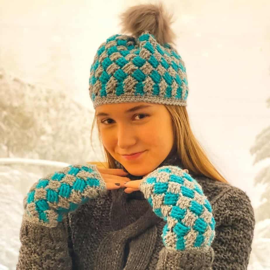 Girl posing with gray and turquoise winter hat and fingerless gloves.