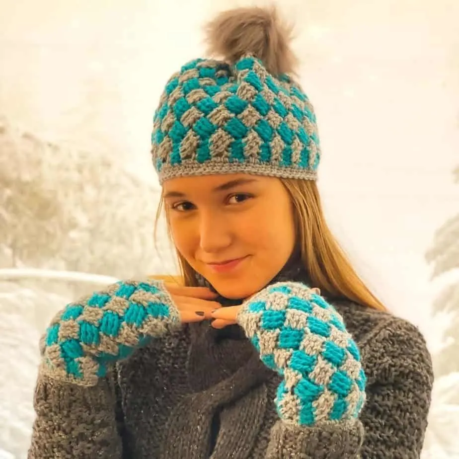 Girl posing with gray and turquoise winter hat and fingerless gloves.
