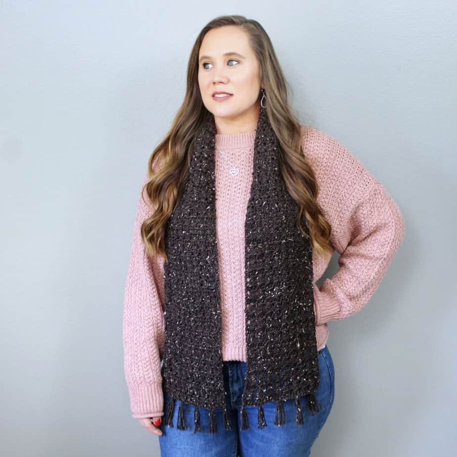 Woman wearing long dark-colored scarf.