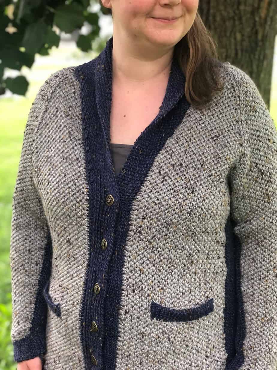 Woman wearing beige and black crochet sweater.