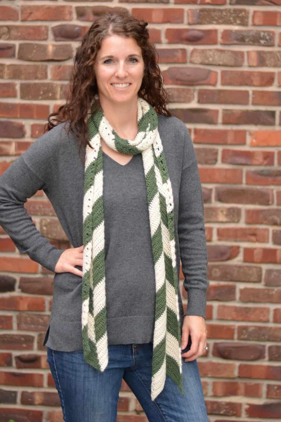 Woman earing write and green striped scarf.