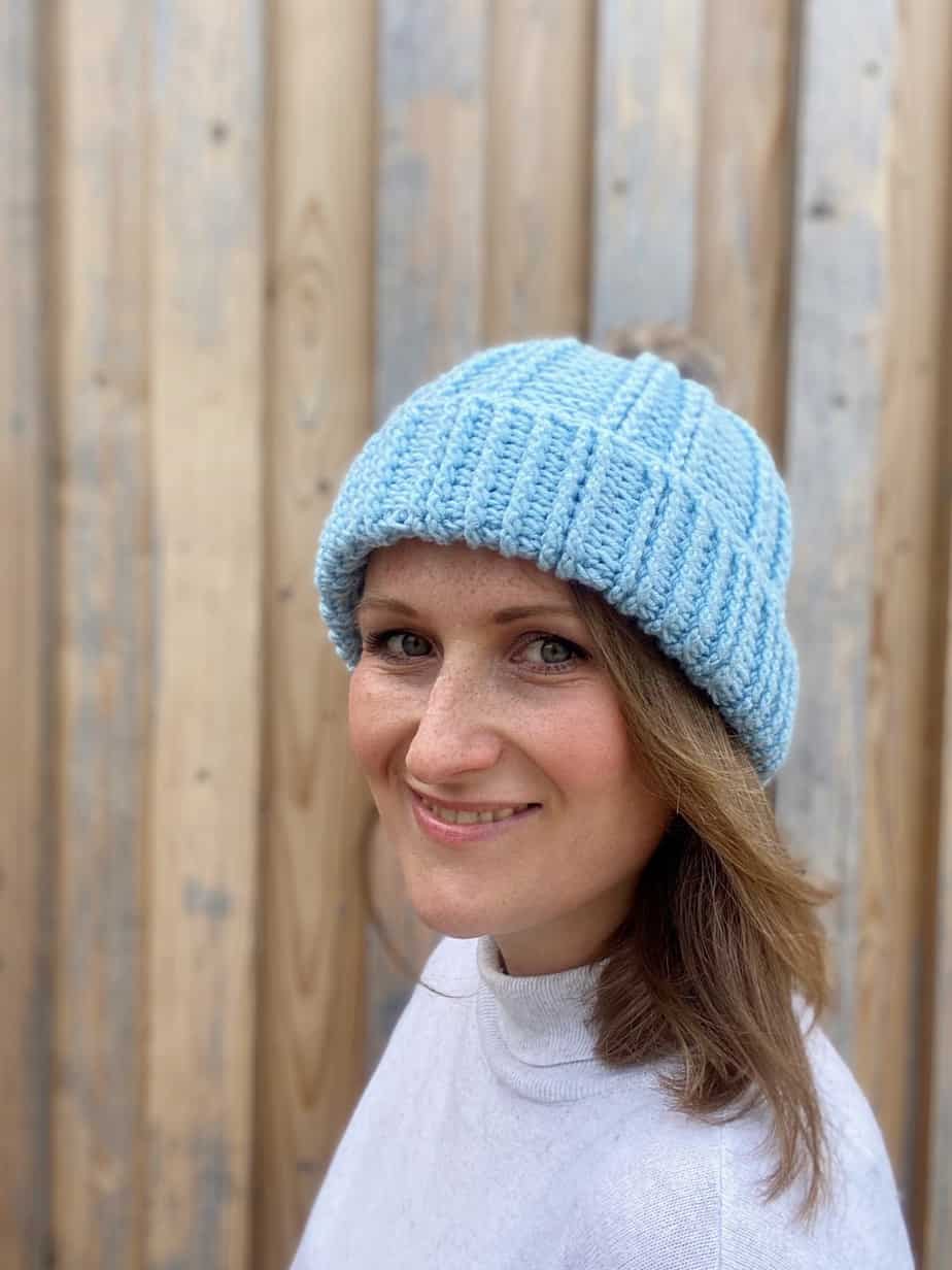 woman wearing blue textured crochet bobble hat