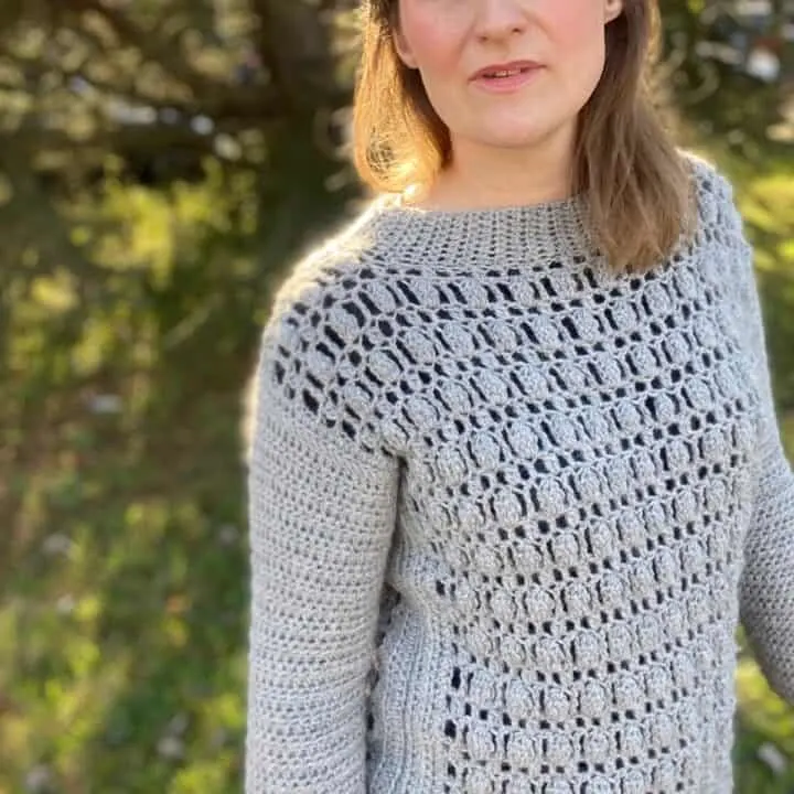 woman wearing textured crochet sweater in grey
