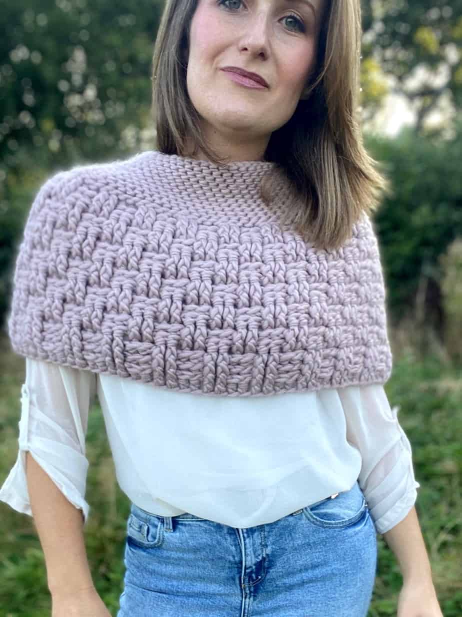 woman facing camera wearing pink basketweave stitch crochet capelet