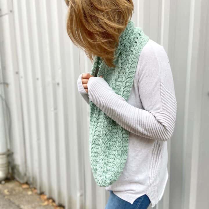 mint crochet cable scarf pattern on woman in jumper and jeans