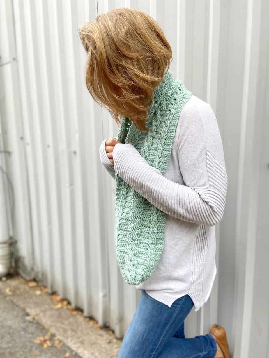 mint crochet cable scarf pattern on woman in jumper and jeans