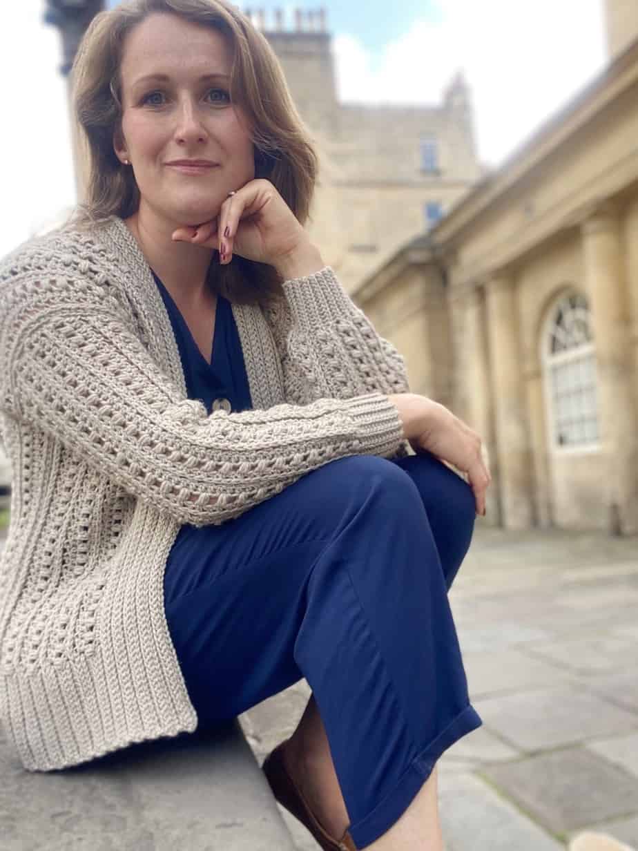 woman wearing cream puff stitch crochet cardigan sitting on steps in Bath.