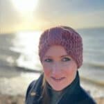 woman on the beach wearing chunky crochet headband pattern in pink