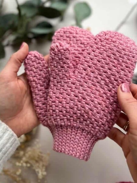 person holding moss stitch crochet mittens that look like knitting