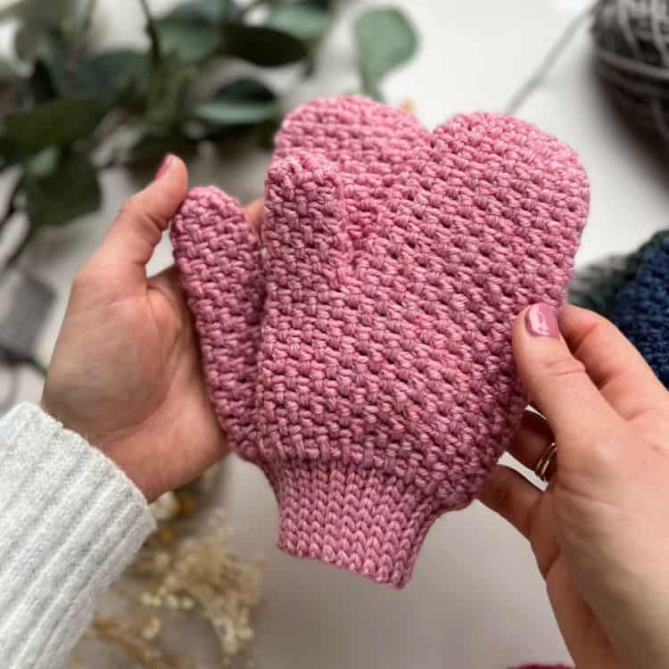 person holding moss stitch crochet mittens that look like knitting