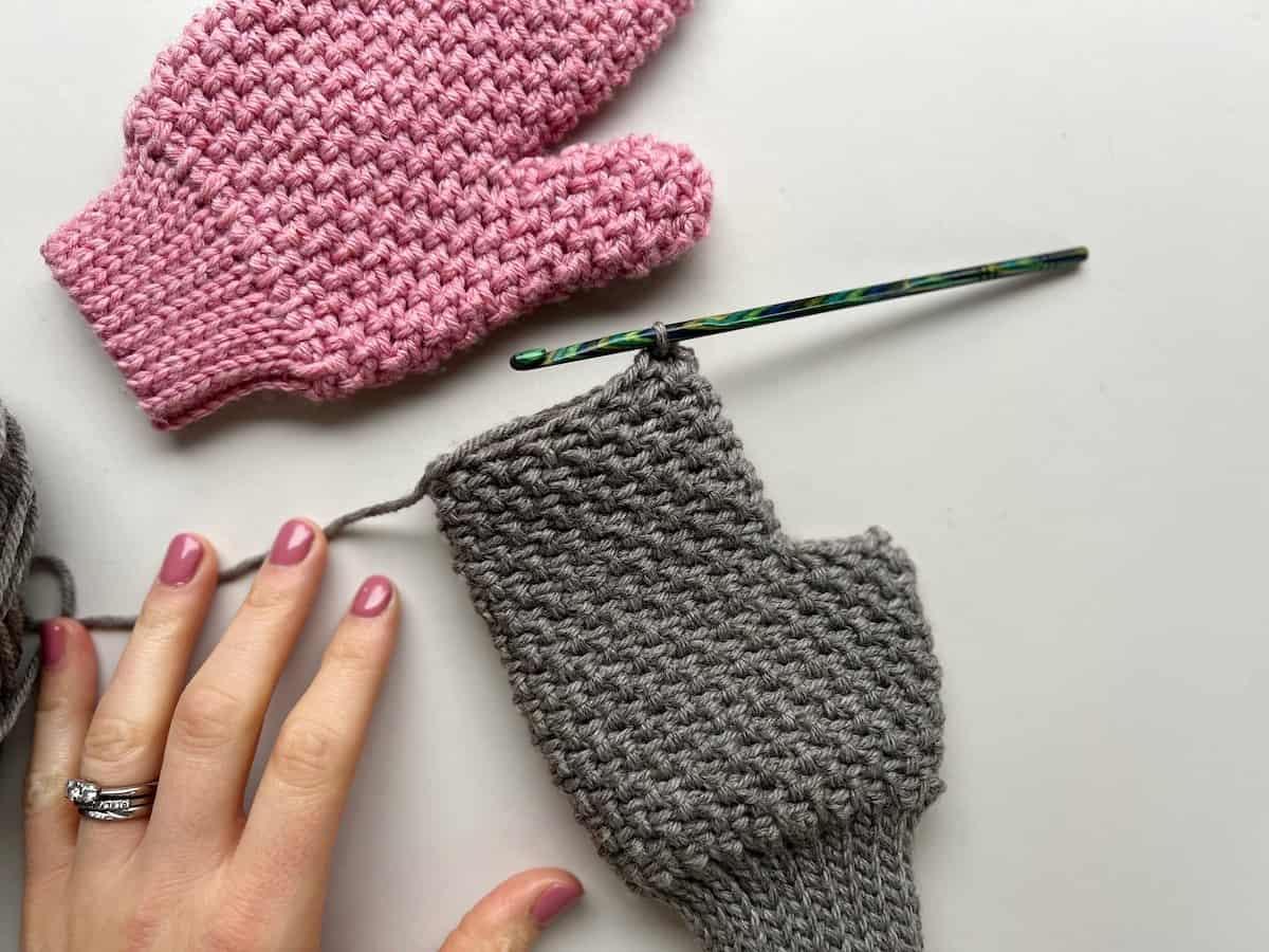 progress image of crochet mittens in herringbone moss stitch without fingers or thumb yet.