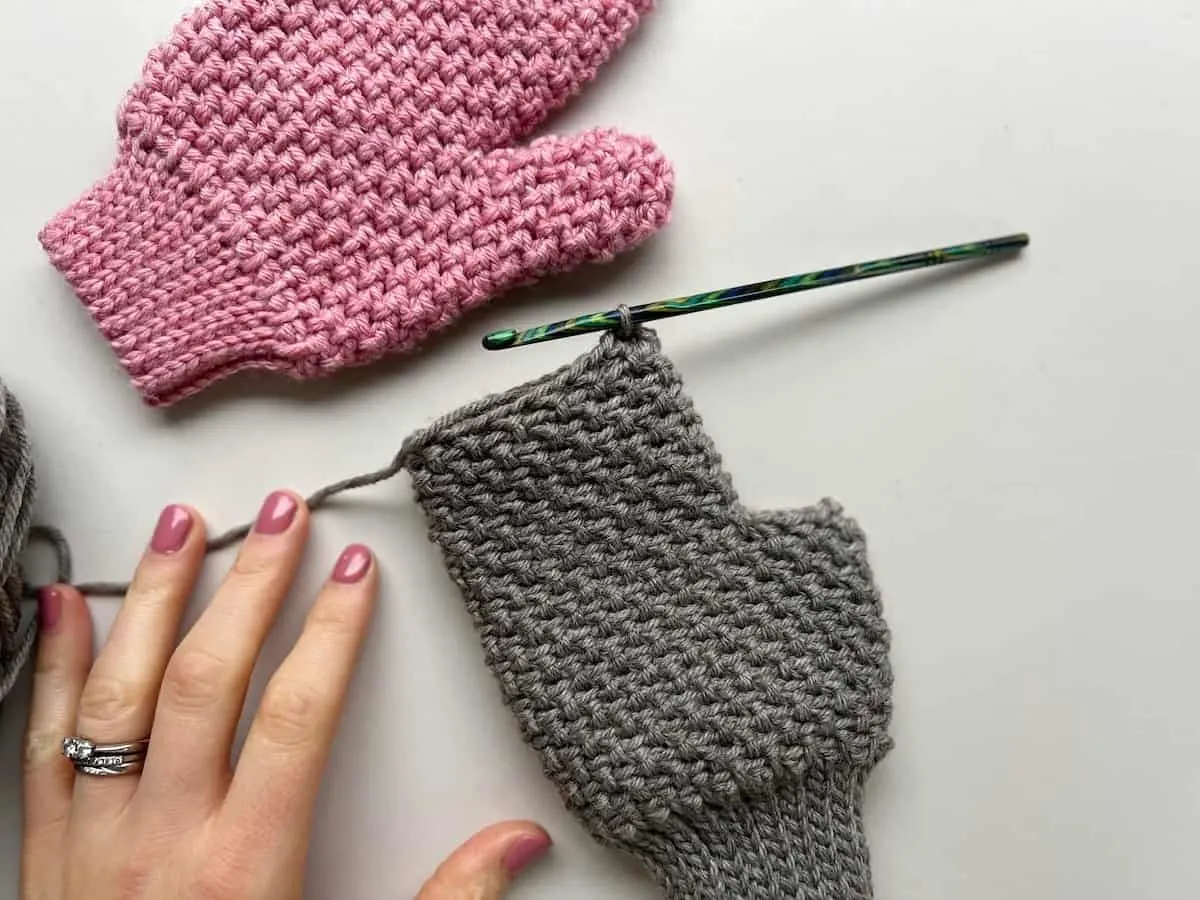 progress image of crochet mittens in herringbone moss stitch without fingers or thumb yet.