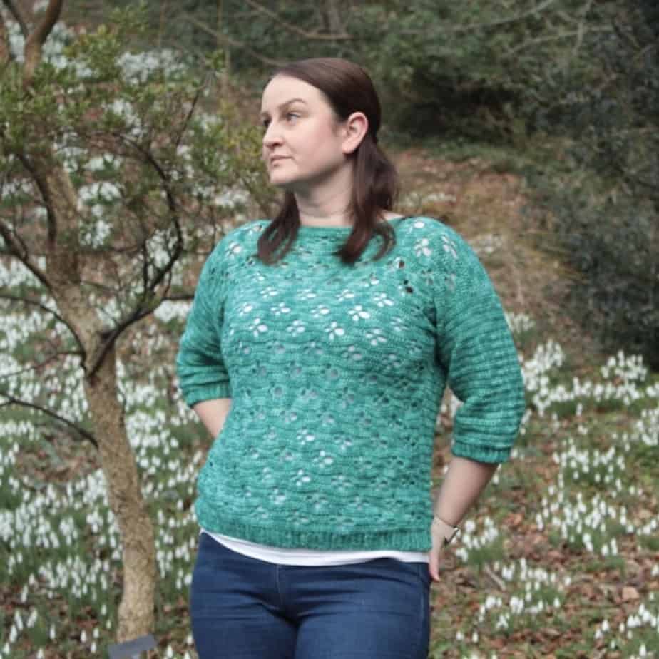 Woman wearing green crochet sweater.