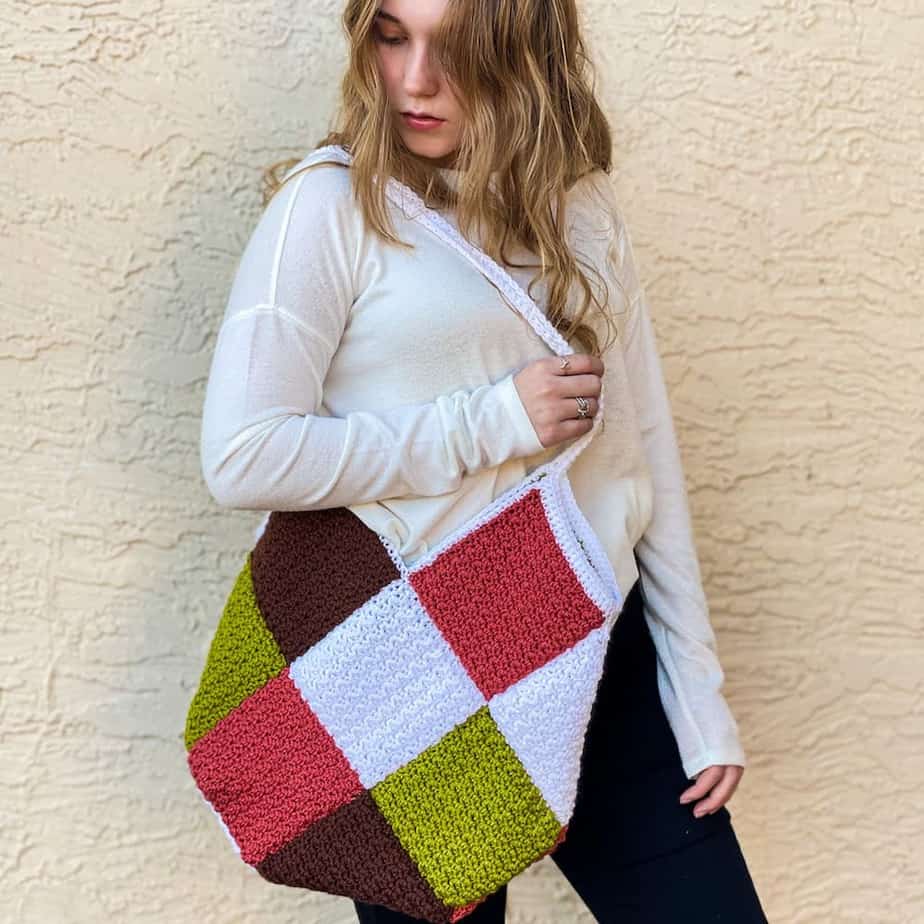 Woman holding colorful bag over her shoulder.