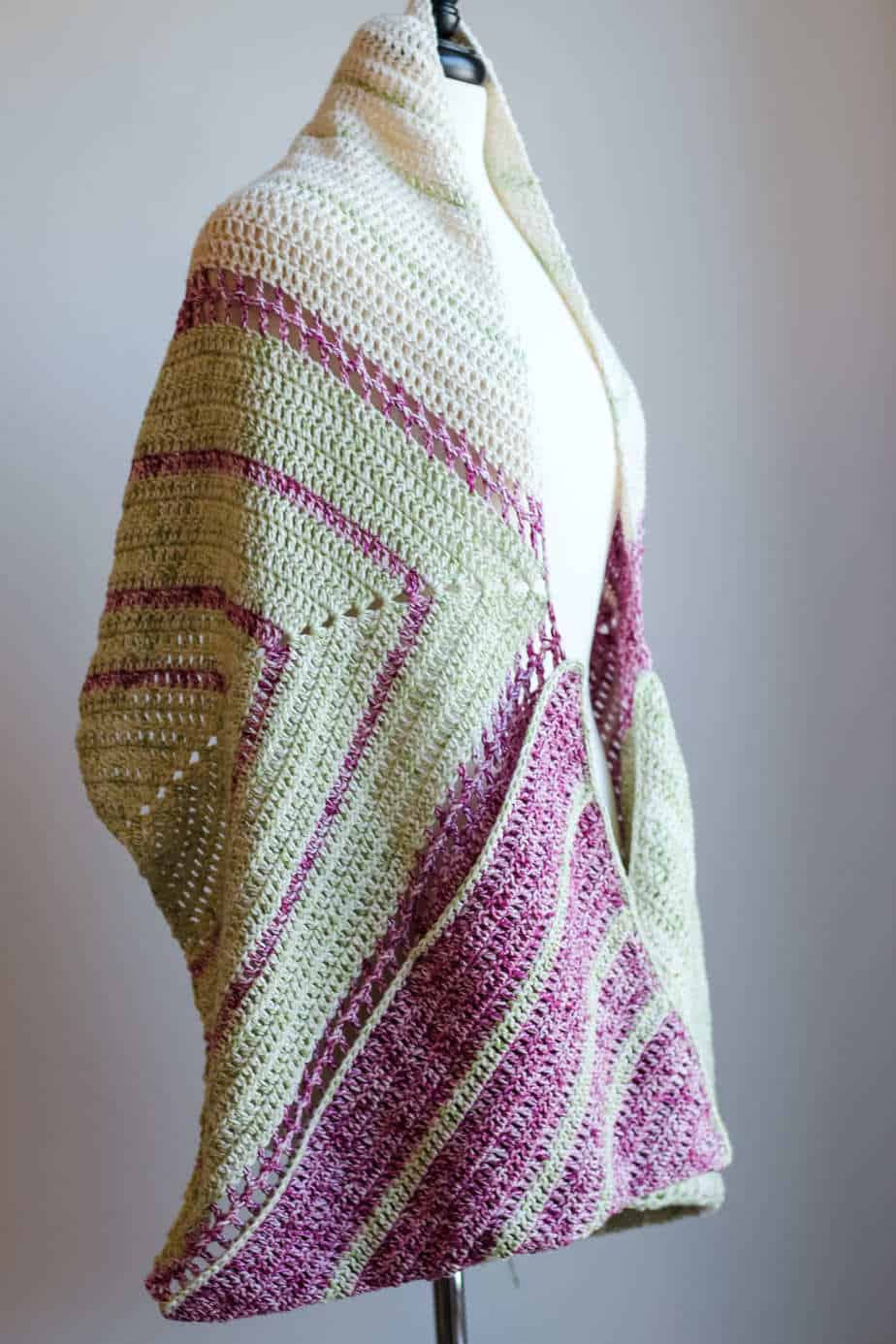 Purple and cream shawl draped over a dress form.