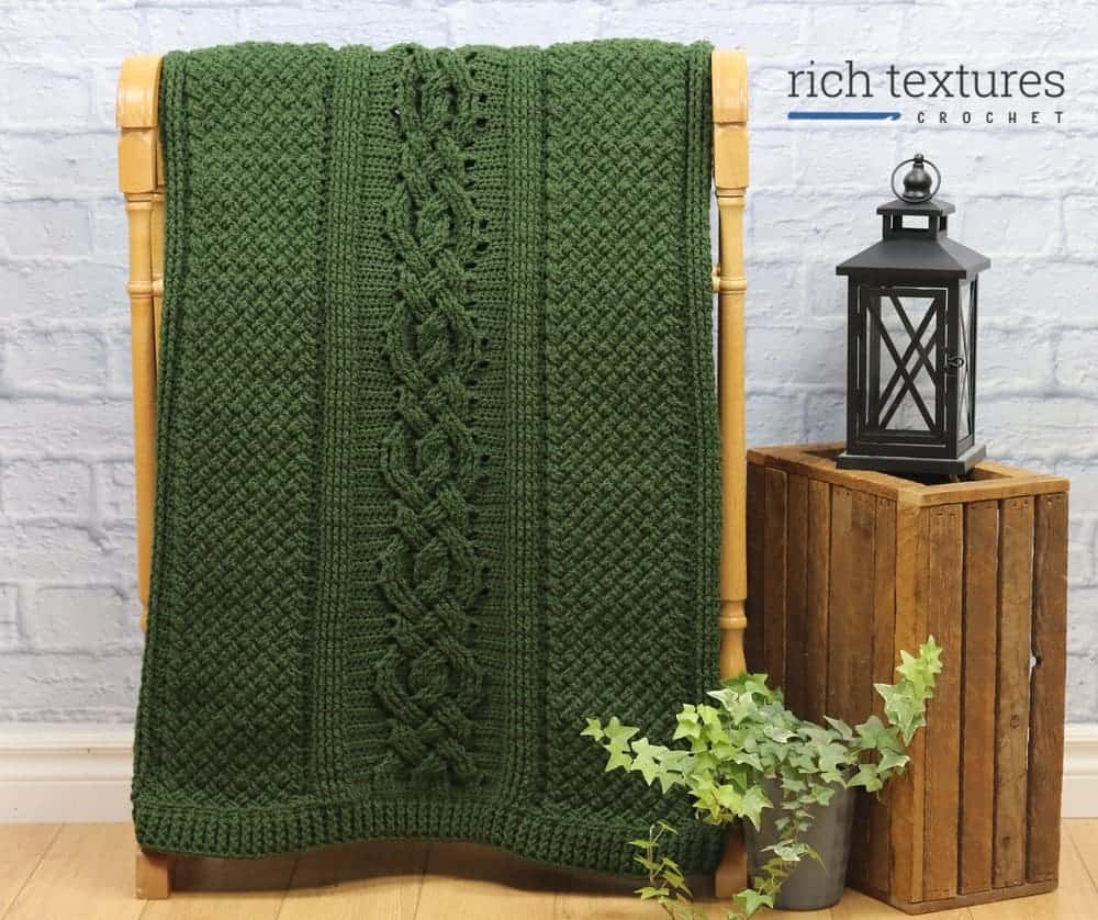 Dark green throw blanket draped over blanket rack.