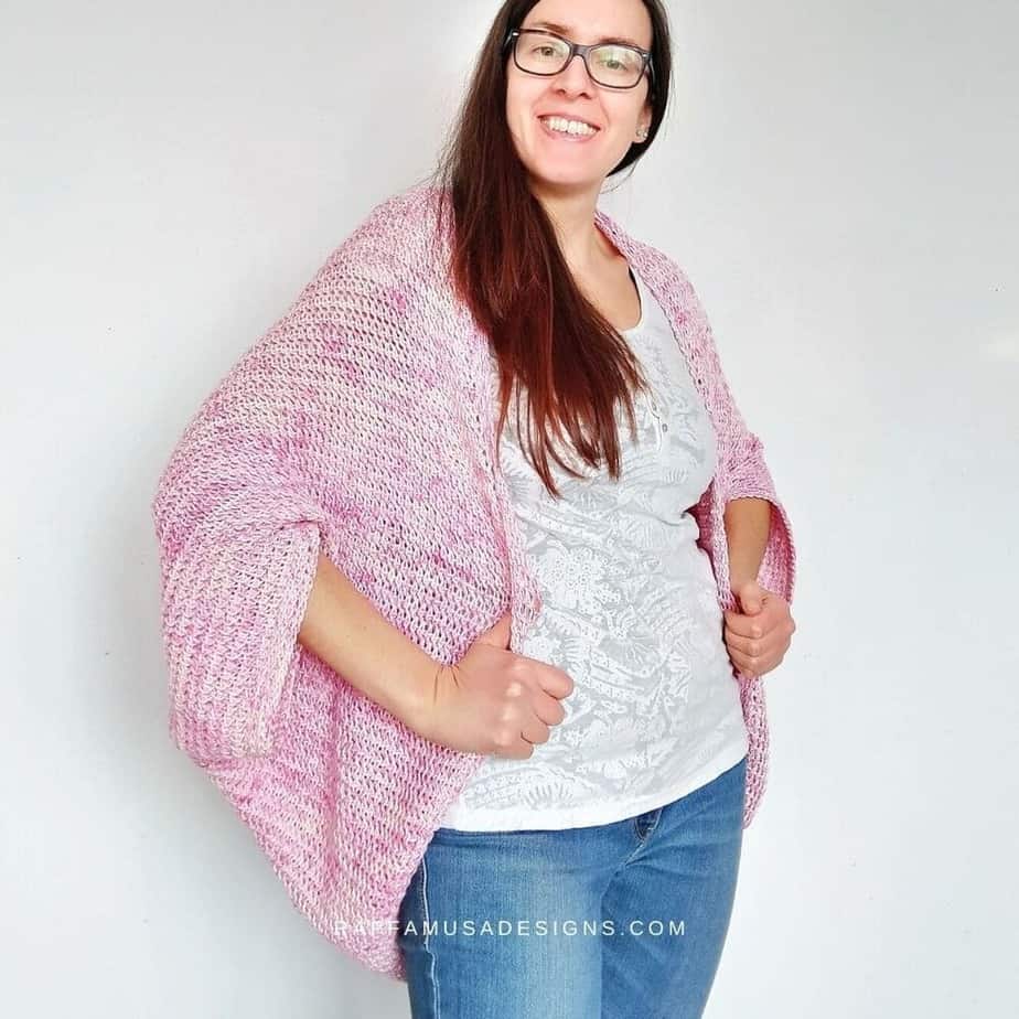 Smiling woman modeling pink crochet shrug.