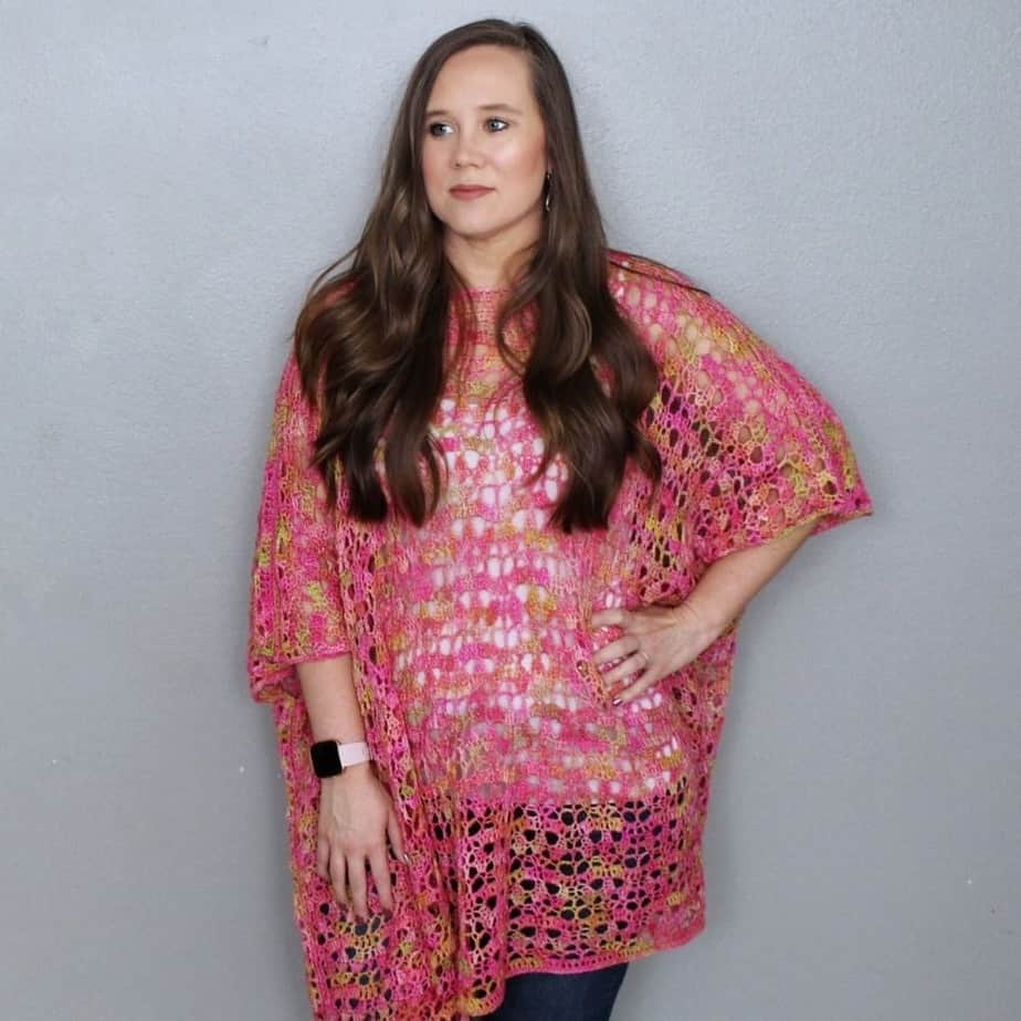 Woman wearing pink lace crochet poncho.