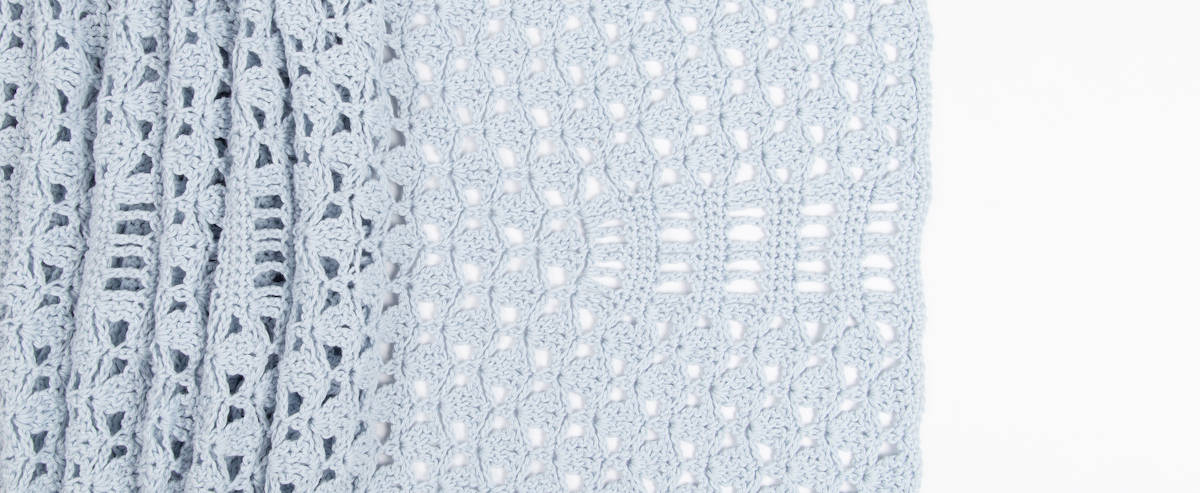 lacy crochet wrap pattern laid out flat on white background showing stitch detail