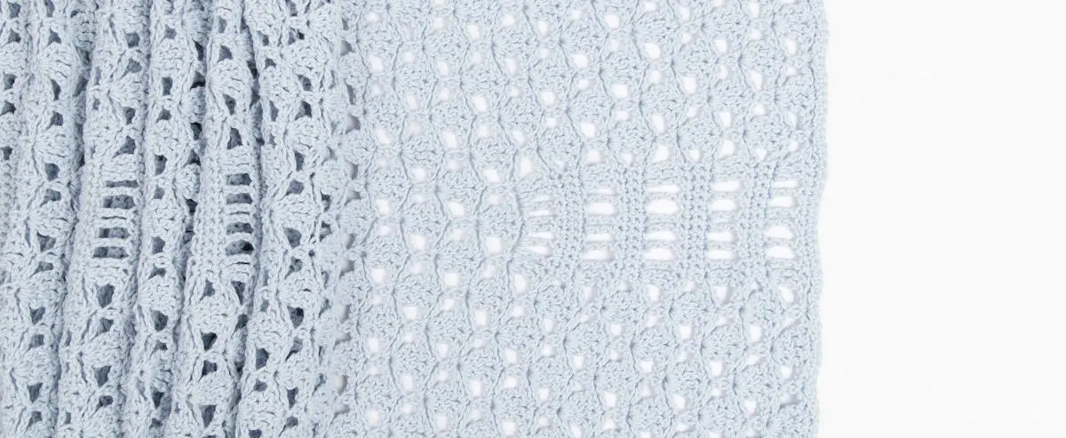 lacy crochet wrap pattern laid out flat on white background showing stitch detail