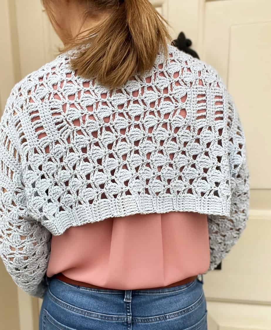 person wearing lacy crochet shrug shown from the back