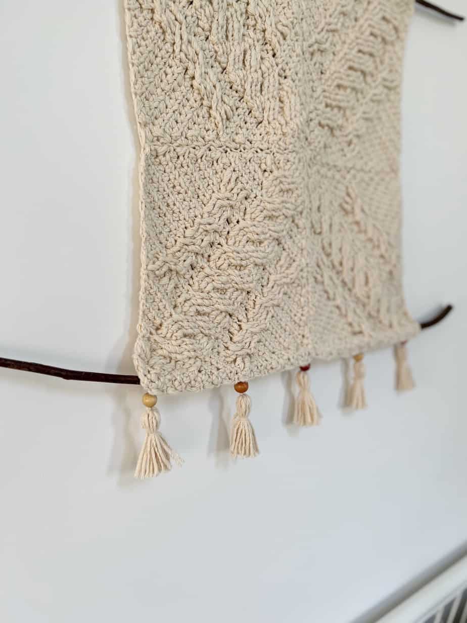 close up of tassels on cream crochet wall hanging