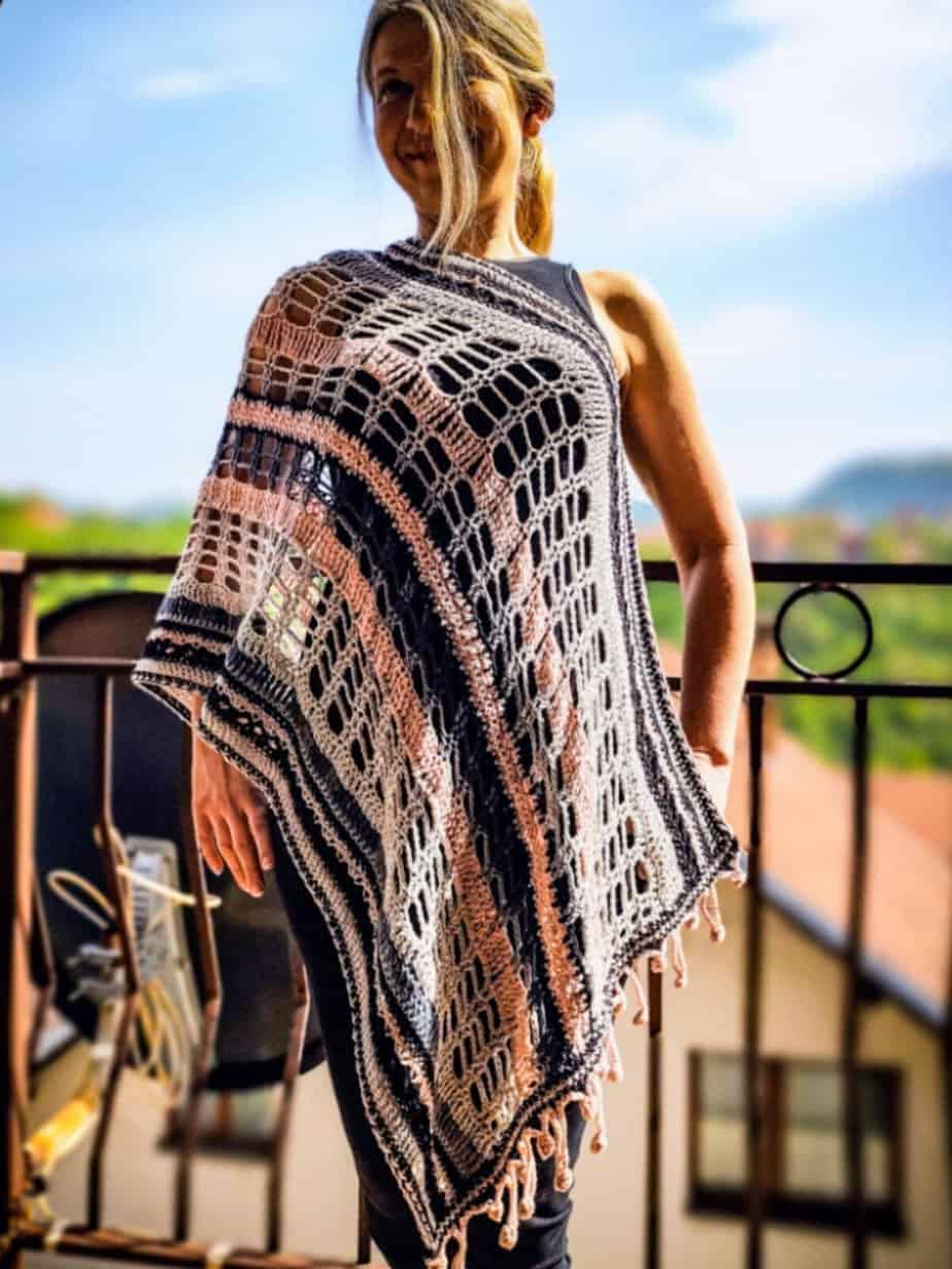 Woman wearing a long lace crochet shawl.