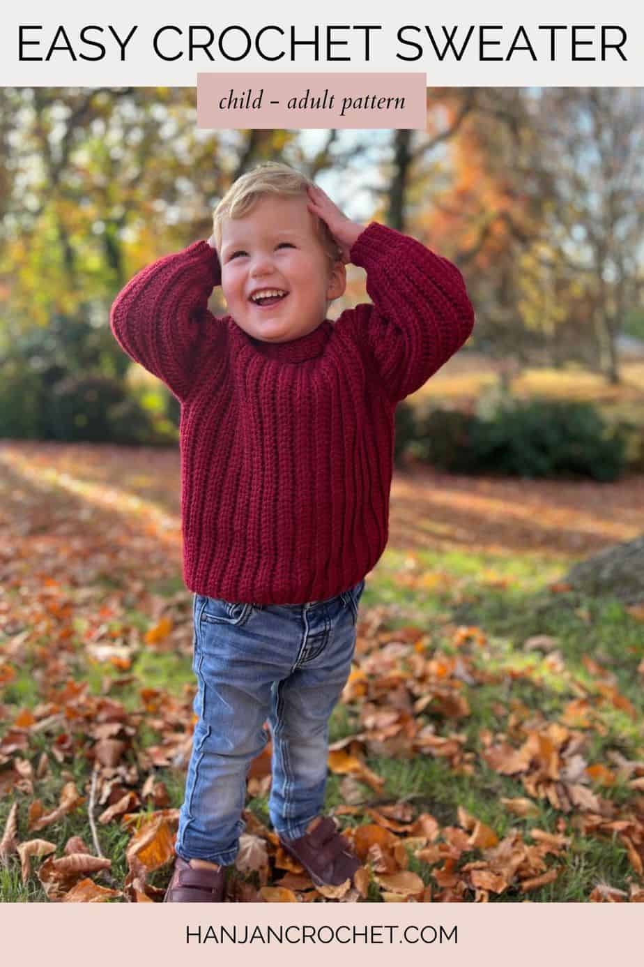 toddler holding his hands on his head and smiling wearing easy crochet sweater pattern that looks like knit