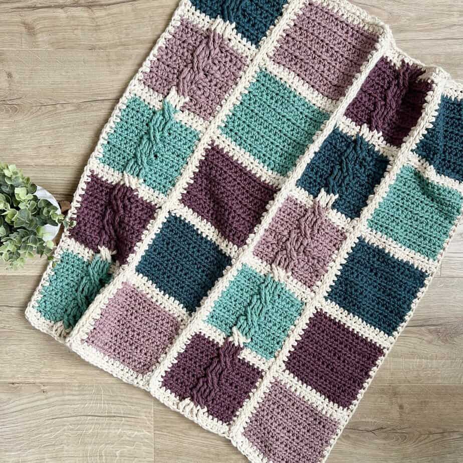 Patchwork Crochet Blanket Pattern laid on floor next to houseplant