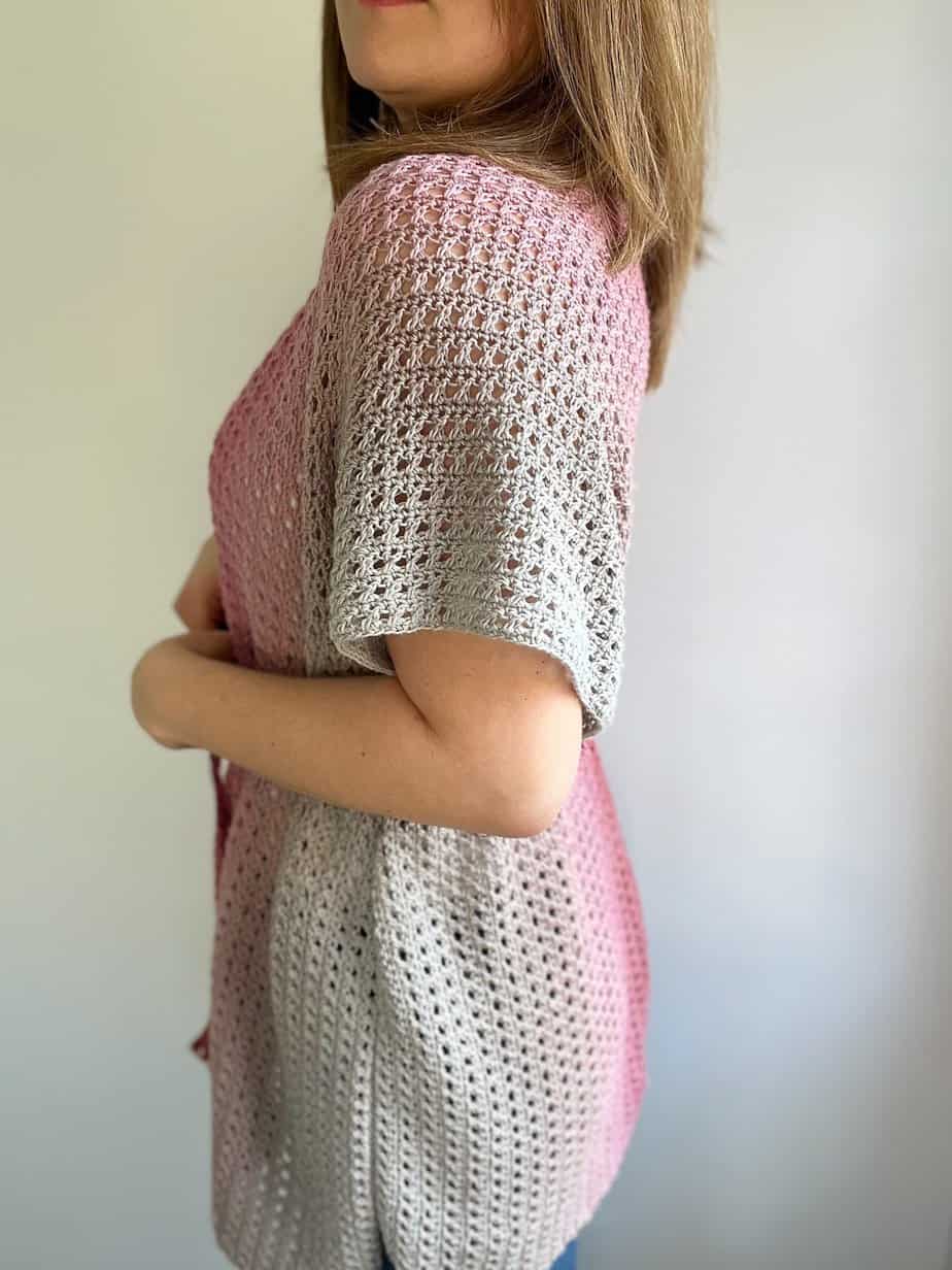Side view of a short sleeved crochet cardigan.