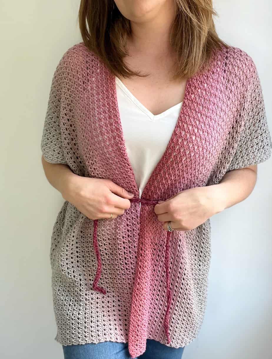 Woman wearing grey and pink summer crochet cardigan pattern.
