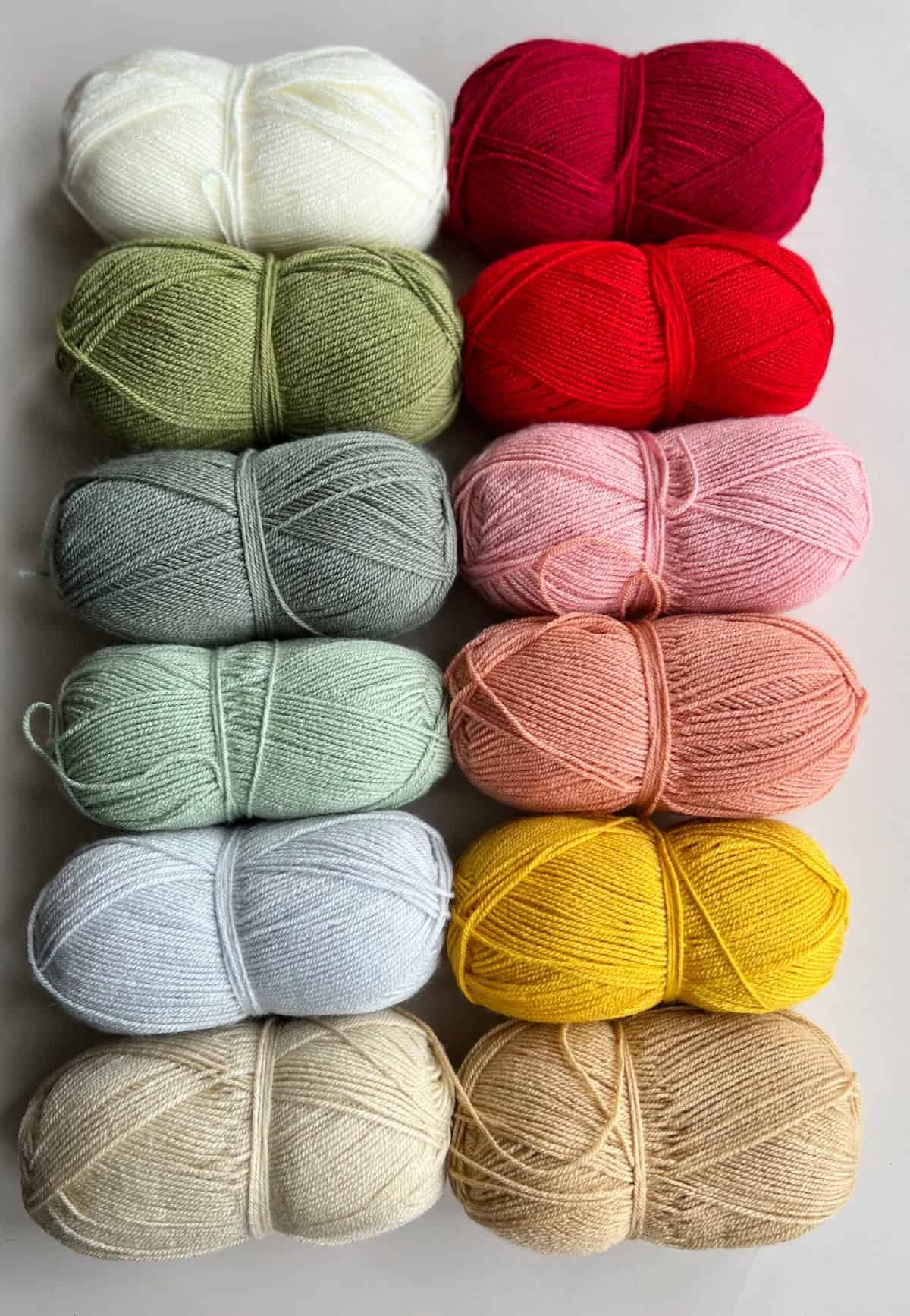 Image showing 12 shades of Paintbox Simply DK yarn used for the Strawberries and Cream crochet blanket pattern.