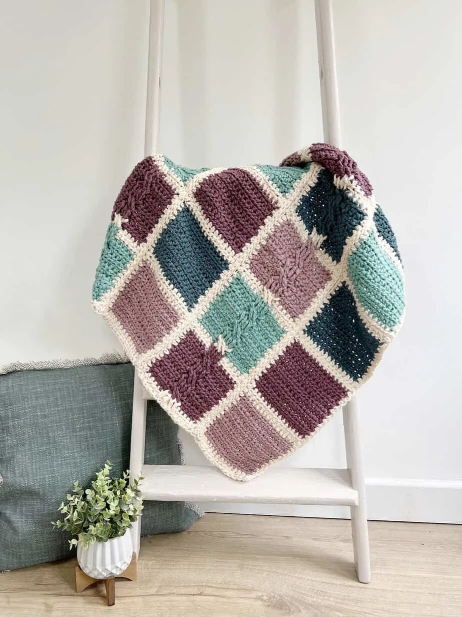 Bulky baby crochet blanket pattern hanging on ladder.