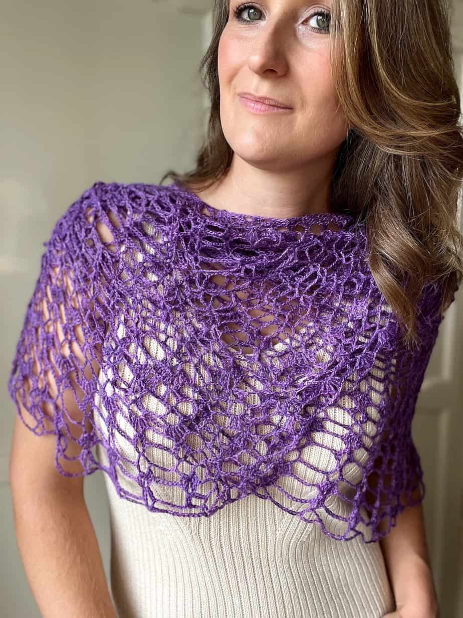 Close up of woman wearing lace crochet shawl wrapped around to form a cowl.