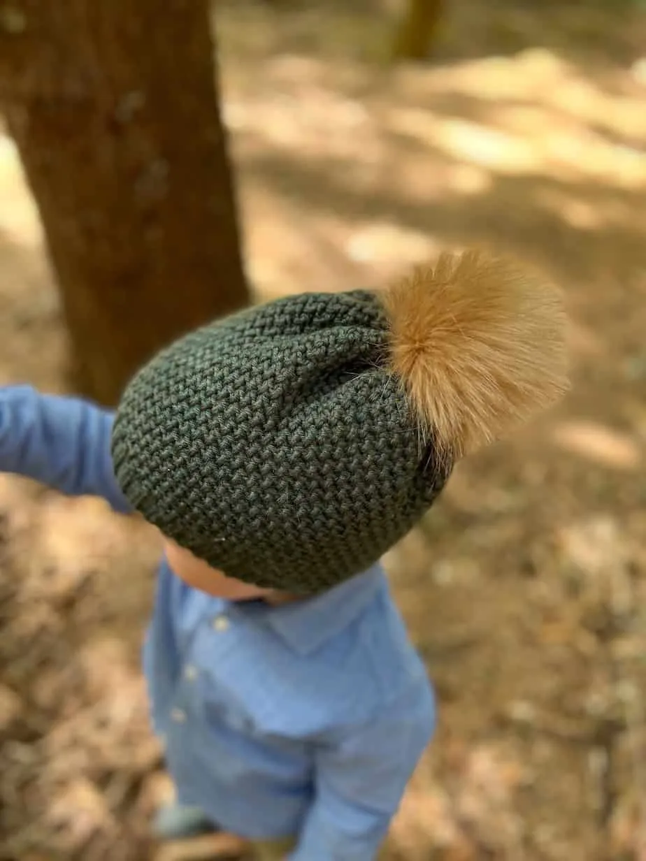 Close up of child wearing crochet hat that looks like knitting.