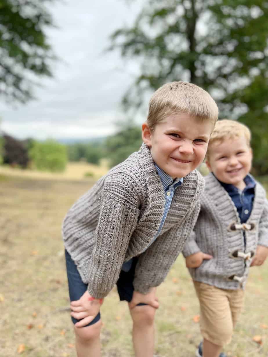 Two children wearing cozy crochet cardigan pattern.