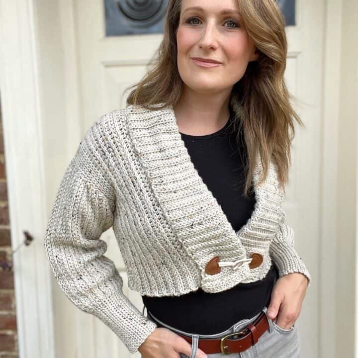 Crop crochet cardigan on a woman with button fastening.