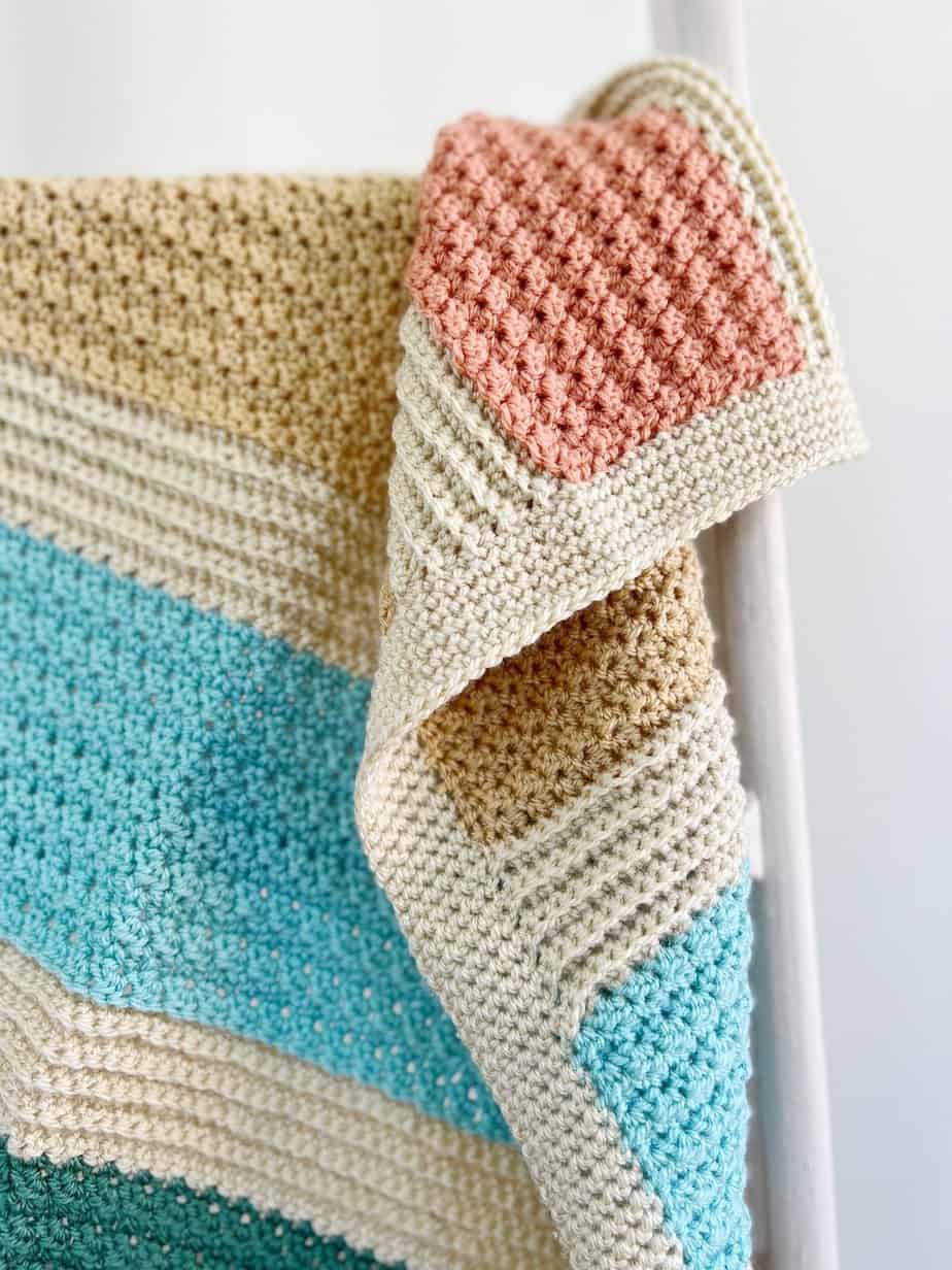 Close up of striped crochet blanket pattern with simple border.