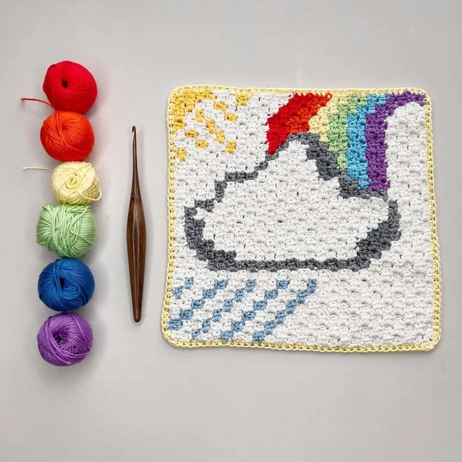 c2c square pattern with rainbow, cloud, sun and showers with hook and yarn.