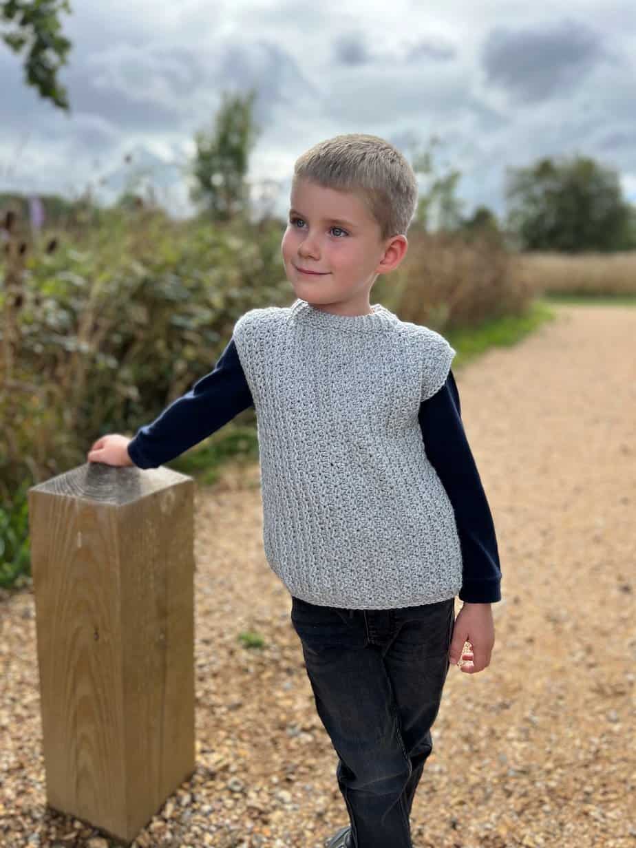 Child wearing grey crochet vest pattern for boys.