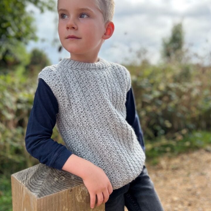 Child wearing grey crochet vest pattern.