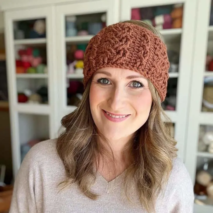 Woman wearing crochet cable headband pattern.