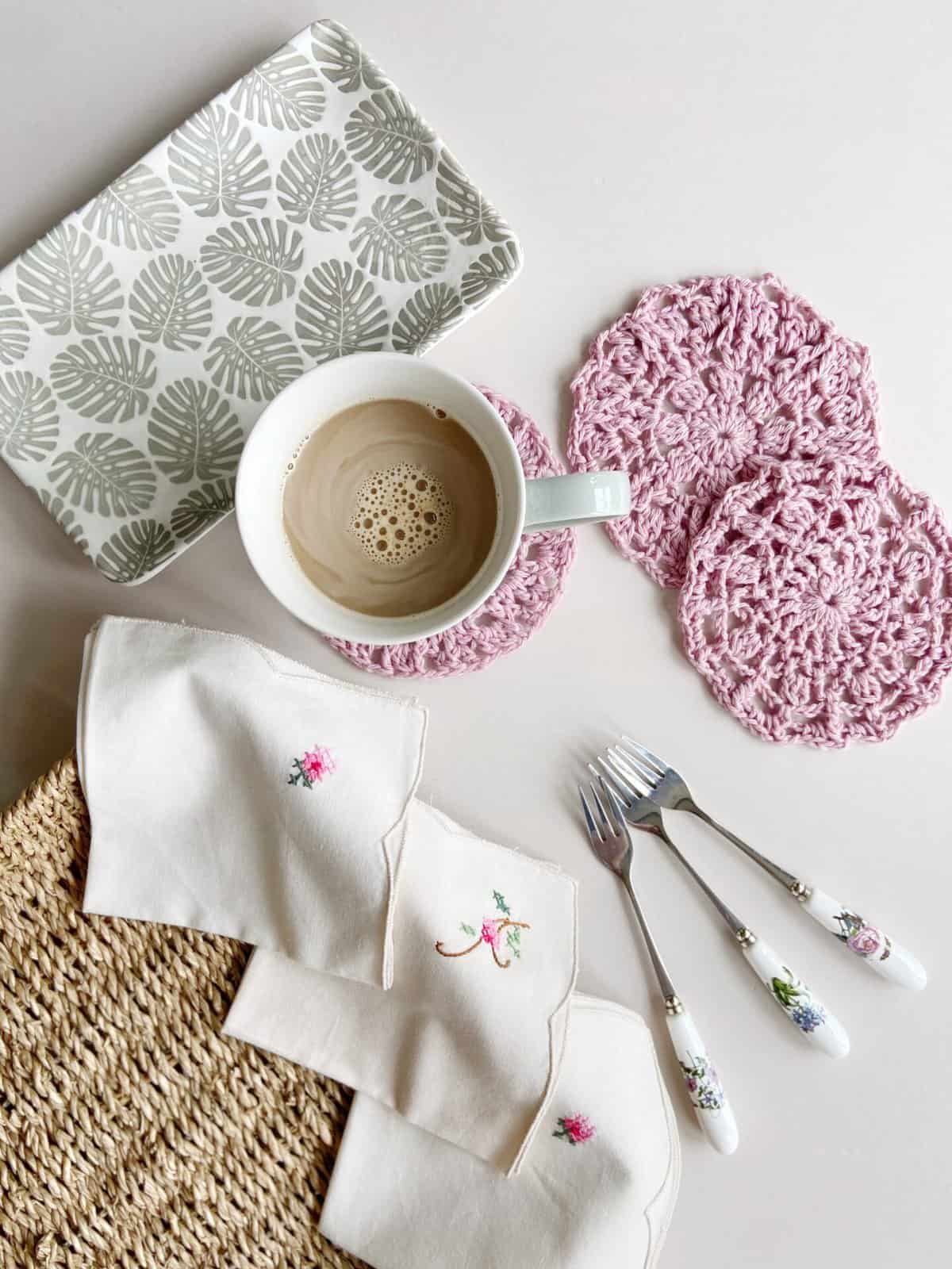 3 lace crochet coasters with napkins and cake forks and coffee.