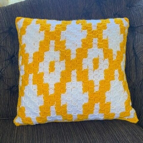 Corner to corner crochet pillow pattern in yellow and white.