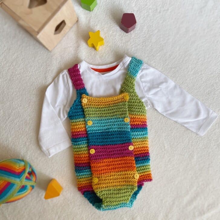 Rainbow baby crochet romper pattern with little yellow buttons.