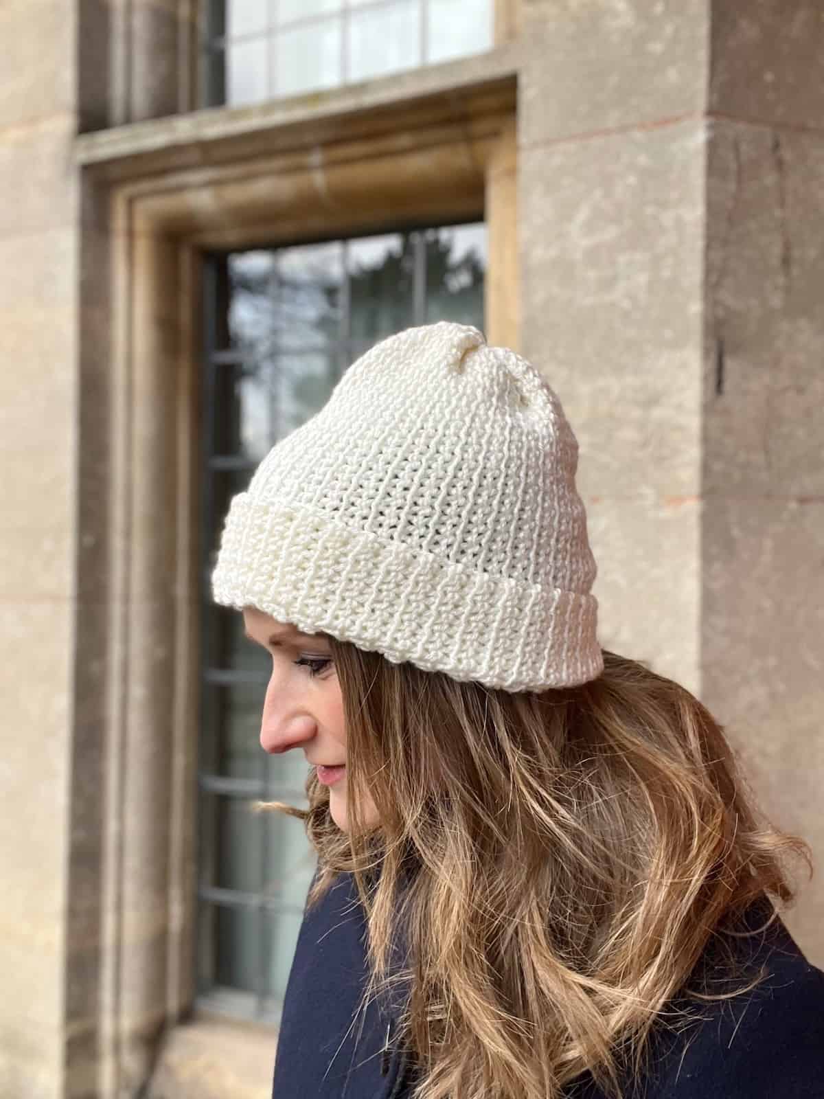 Woman looking sideways wearing modern crochet hat.