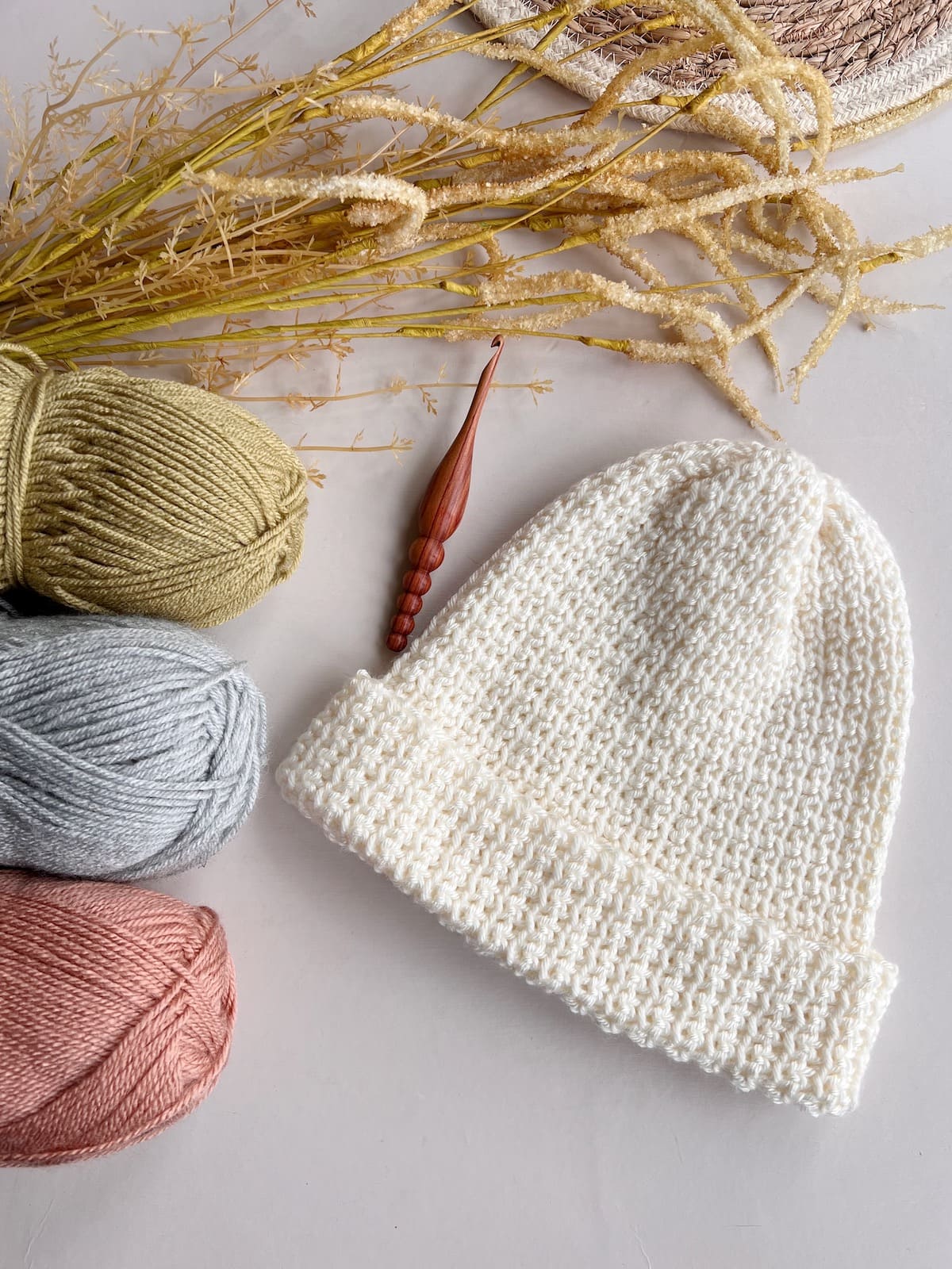 Free crochet beanie pattern in all sizes with crochet hook and balls of yarn.